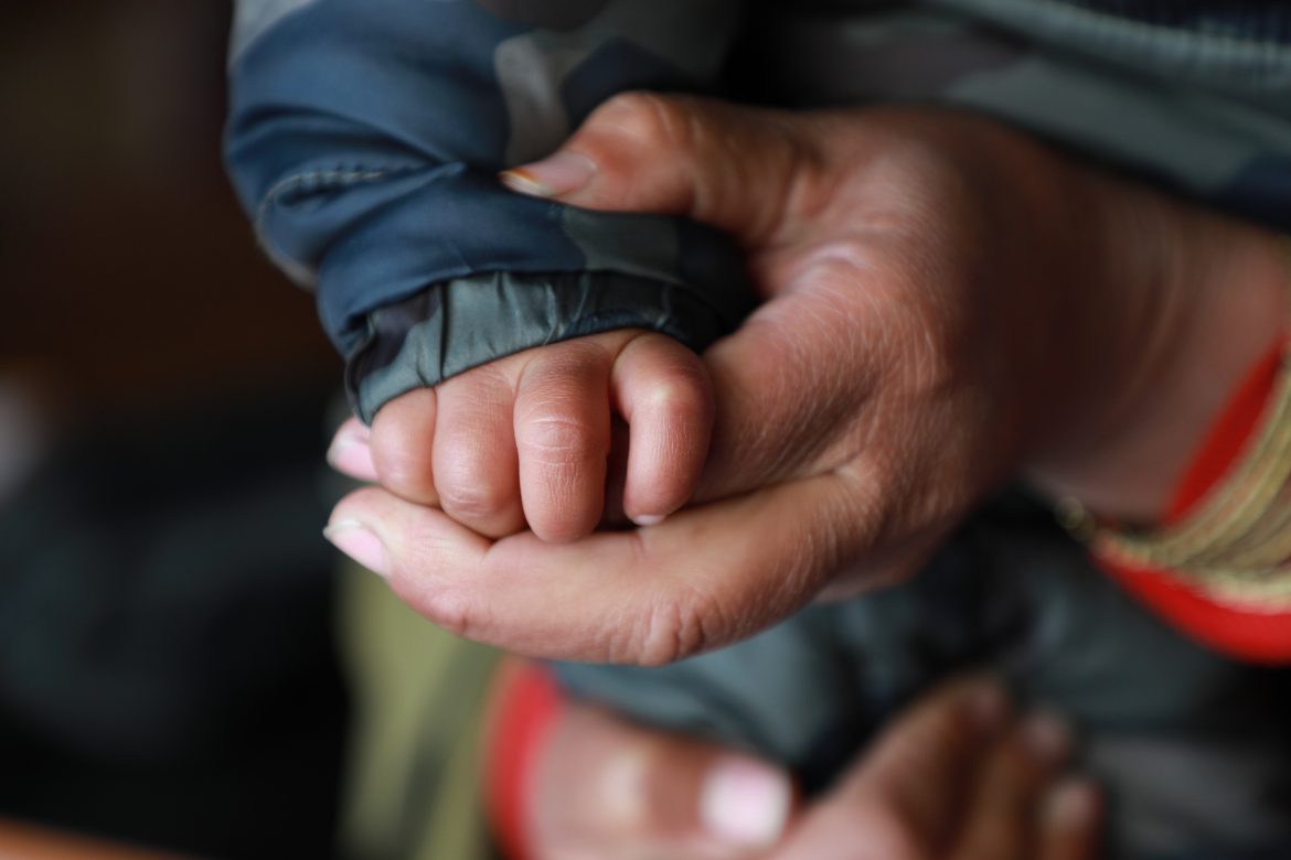 Erwachsene Hand hält Kinderhand, Afghanistan