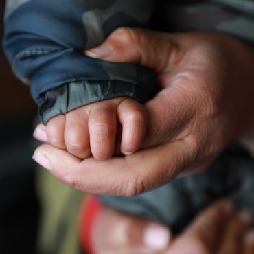 Erwachsene Hand hält Kinderhand, Afghanistan