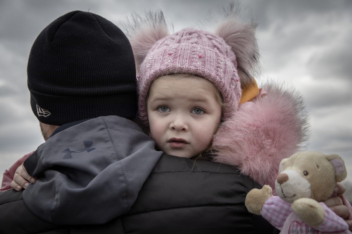 Mann trägt kleines Mädchen mit Teddybär, Ukraine