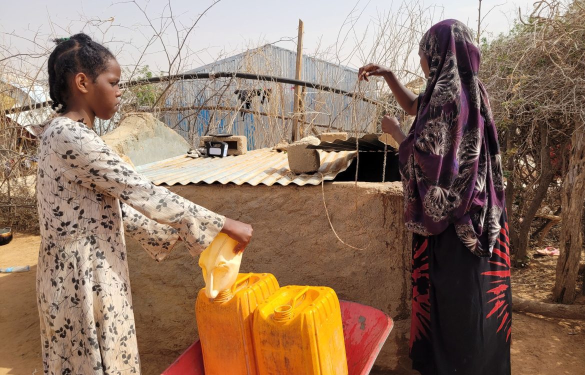 Somalia, Frau und Mädchen holen Wasser aus einem Brunnen, Asha