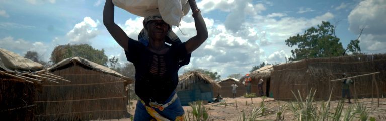 Mosambik (Ostafrika). Cecilia eine von 900.000 Menschen, die vor dem Ausbruch der Gewalt in Cabo Delgado im Oktober vor sechs Jahren fliehen musste. Hier transportiert sie die dringend notwendigen Güter wie Planen und Decken, um sich ein neues Zuhause aufzubauen.