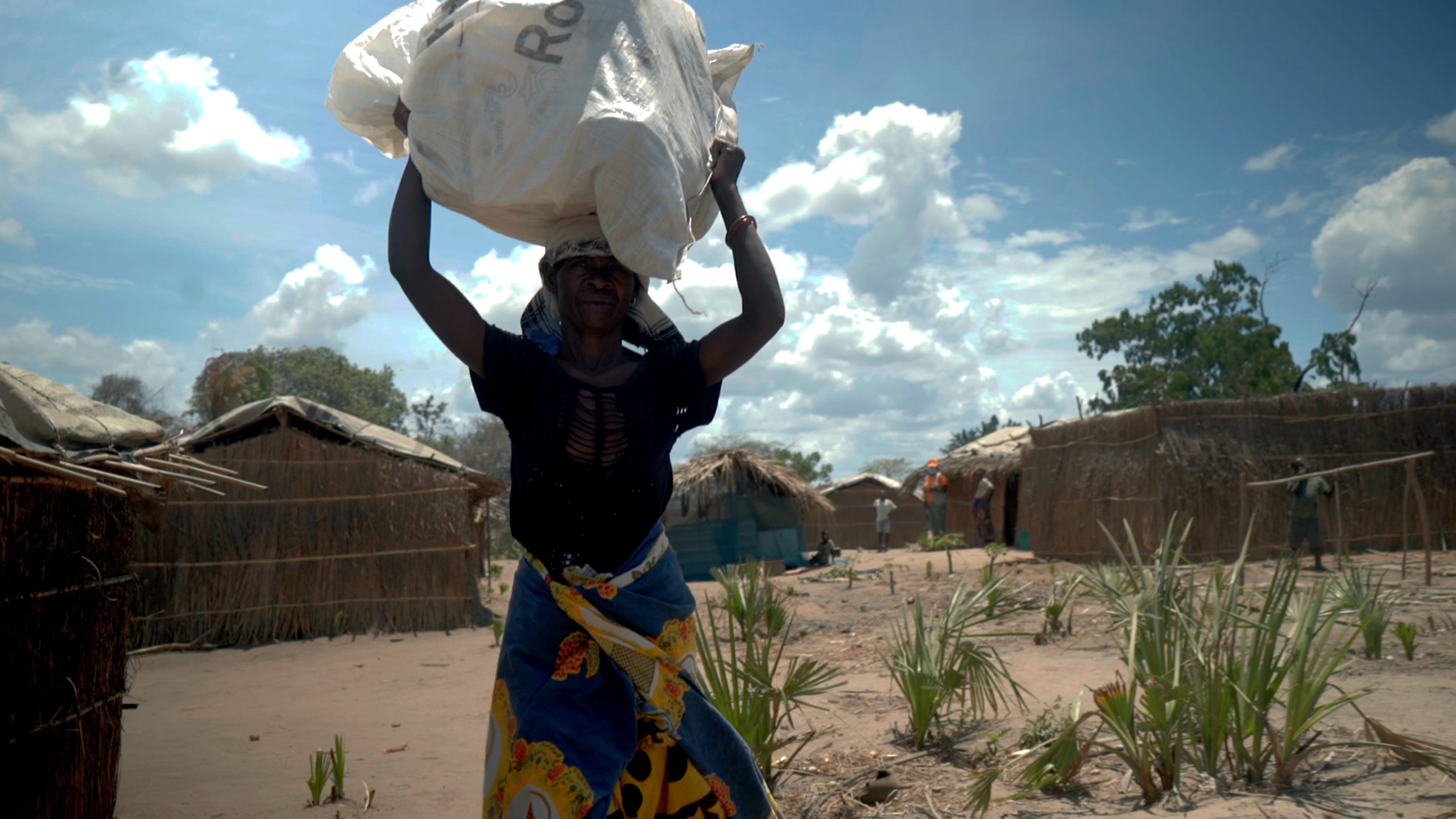 Mosambik (Ostafrika). Cecilia eine von 900.000 Menschen, die vor dem Ausbruch der Gewalt in Cabo Delgado im Oktober vor sechs Jahren fliehen musste. Hier transportiert sie die dringend notwendigen Güter wie Planen und Decken, um sich ein neues Zuhause aufzubauen.