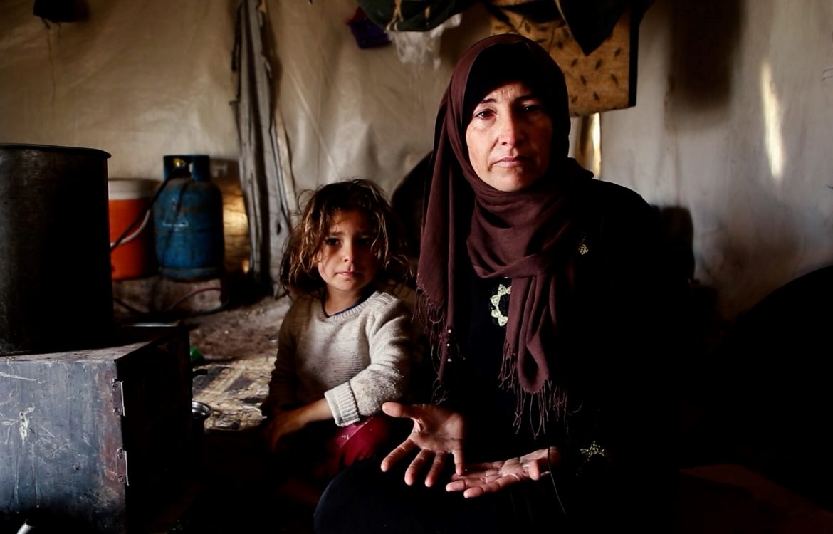 Winterhilfe für Syrien. Die Vorbereitungen laufen. Hier im Bild Mutter Um-Ahmed mit ihrer kleinen Tochter. Sie sitzen im provisorischen Zelt vor ihrem Ofen. Kinder und Familien haben es besonders schwer im kalten Winter.