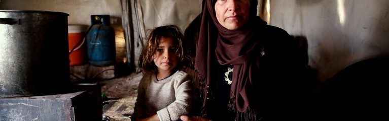 Winterhilfe für Syrien. Die Vorbereitungen laufen. Hier im Bild Mutter Um-Ahmed mit ihrer kleinen Tochter. Sie sitzen im provisorischen Zelt vor ihrem Ofen. Kinder und Familien haben es besonders schwer im kalten Winter.