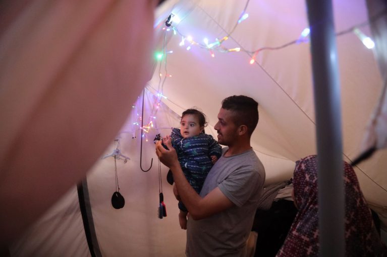 Faisal, seine Frau und eines ihrer Kinder in ihrem Zelt in Rafah, Gaza.