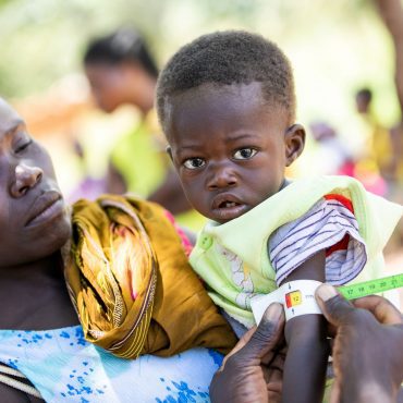 SudanKindMutterKarin Schermbrucker Gesundheitshelfer misst den Oberarm eines Kleinkinds zur Bestimmung des Ernährungszustands