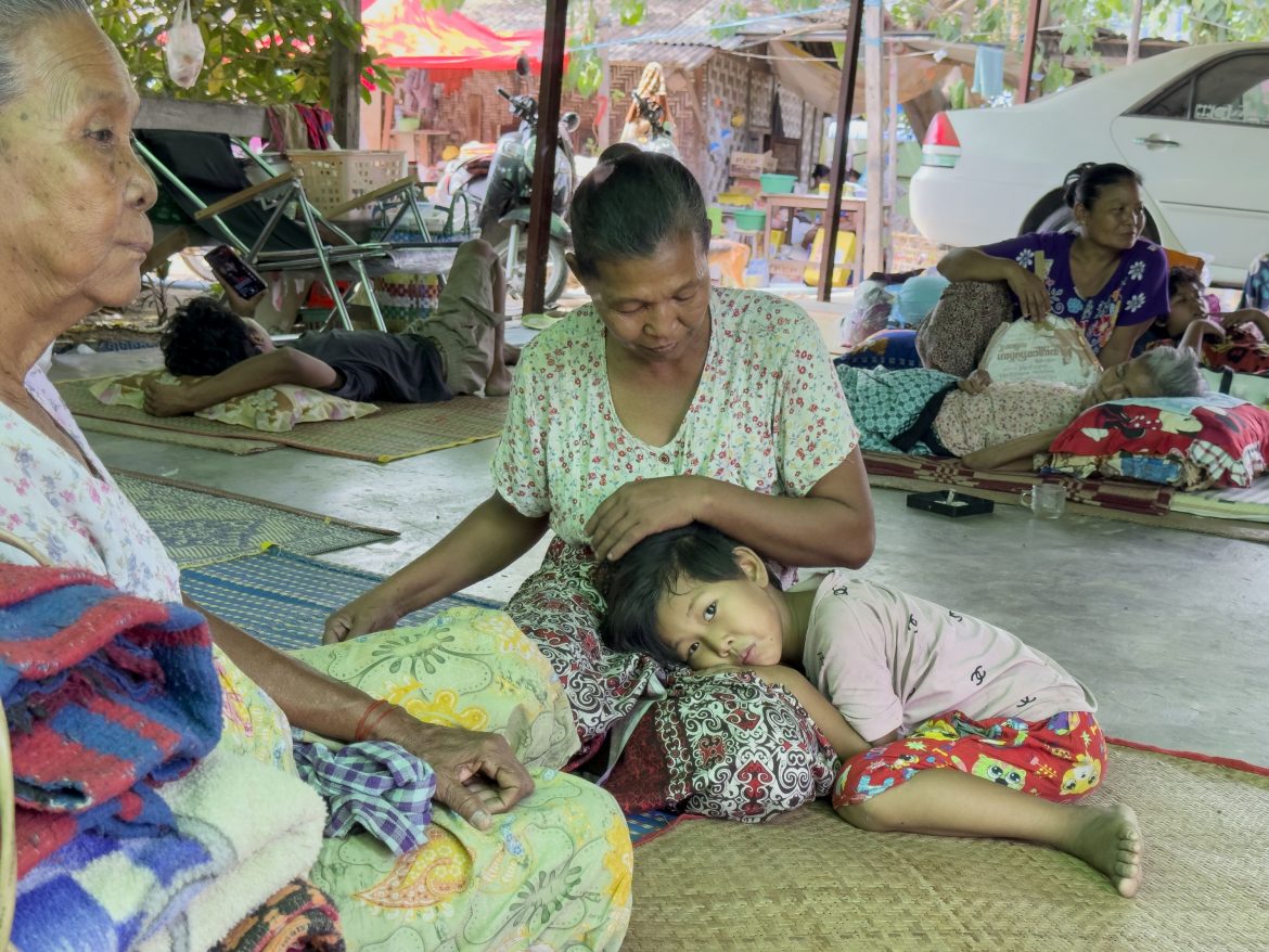 Notunterkunft nach Erdbeben in Myanmar mit Frauen und Kindern auf Bodenmatten ruhend