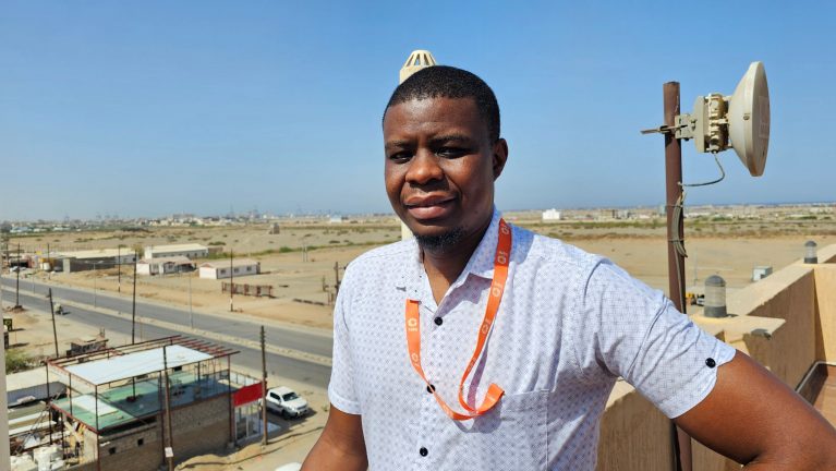 CARE-Mitarbeiter Takunda steht auf der Dachterrasse mit Blick über sudanesische Stadt