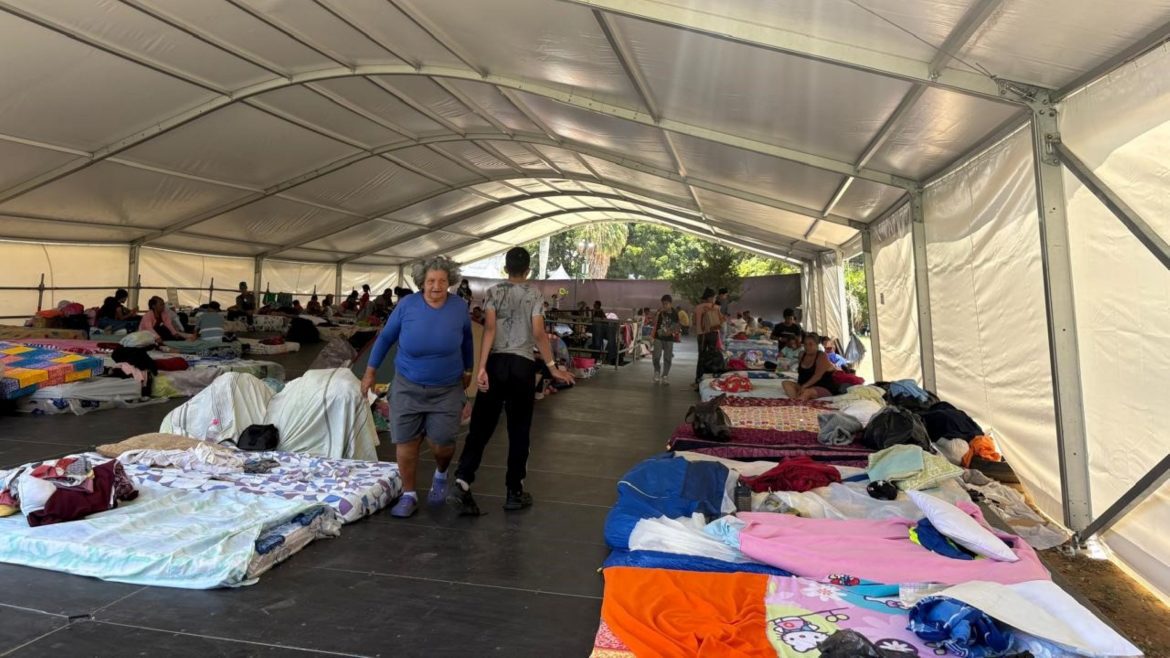 Provisorische Notunterkunft in einem großen Zelt nach dem Erdbeben in Venezuela: zahlreiche Menschen liegen und sitzen auf Matratzen, CARE und Partner unterstützen mit lebenswichtiger Nothilfe.