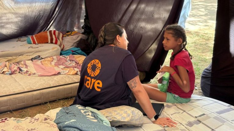 CARE-Mitarbeiterin spricht in einem provisorischen Zelt mit einem Mädchen, das nach dem Erdbeben in Venezuela Schutz sucht.