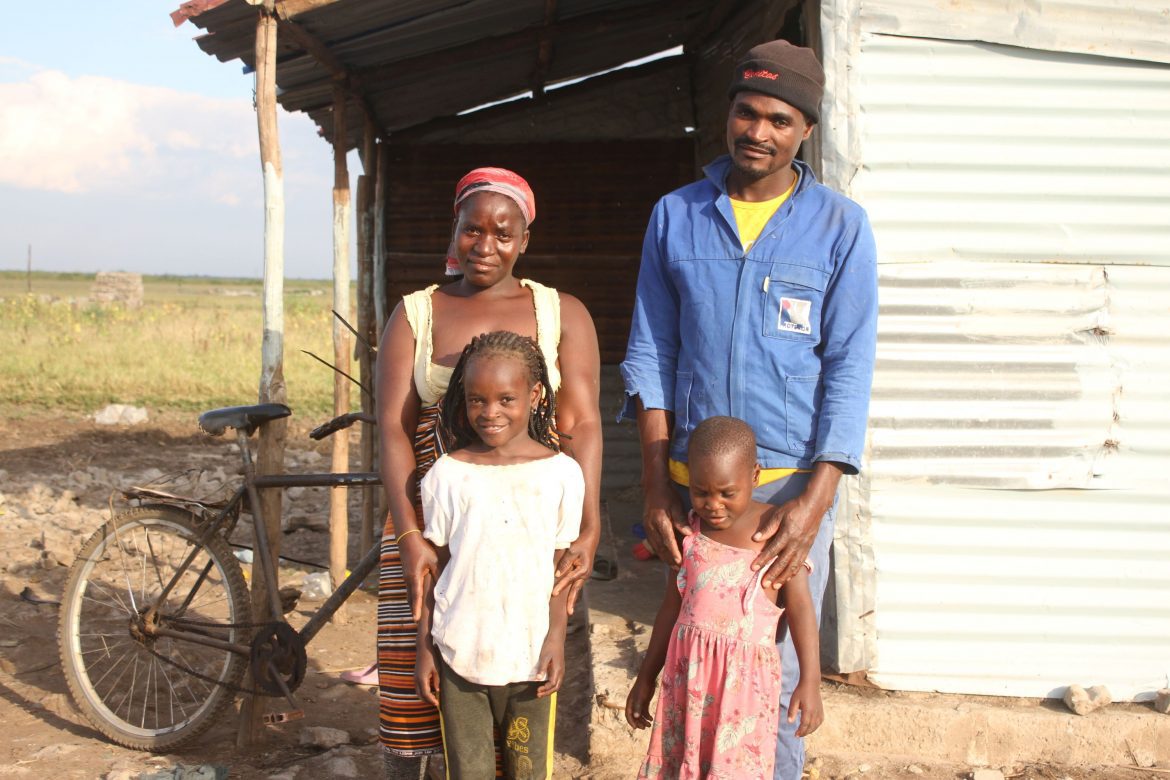 Fernando und seine Familie vor ihrem einfachen Haus aus Wellblech in der Provinz Gaza, Mosambik, die nach Überschwemmungen EU‑finanzierte Nothilfe von CARE erhält.